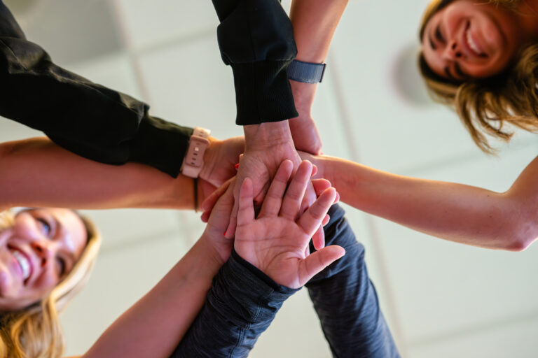 Group Of People In A Circle With Their Hands Inside